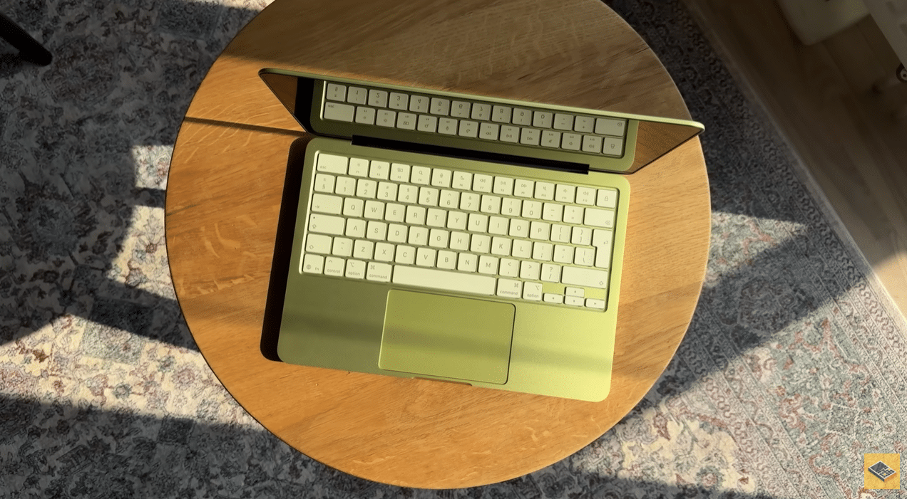 MacBook Neo лимонного кольору, вид зверху на дерев'яному столику