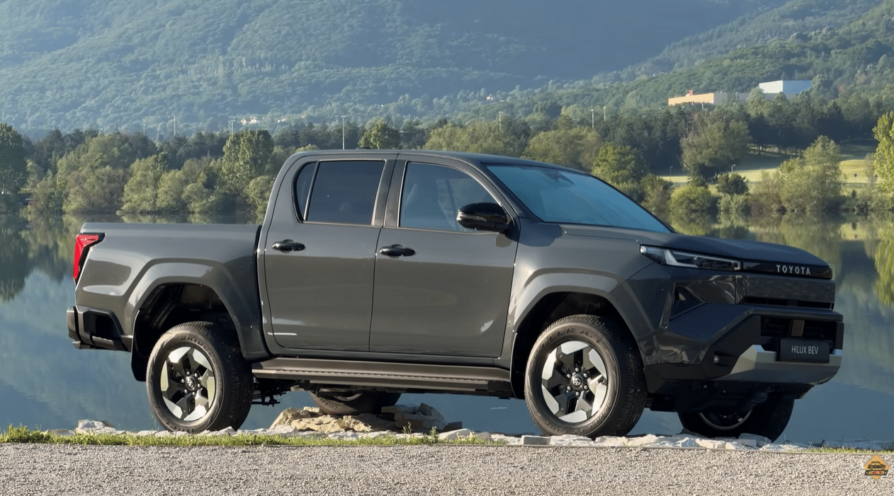 Toyota Hilux BEV темно-сірого кольору на тлі озера та гір — вид збоку