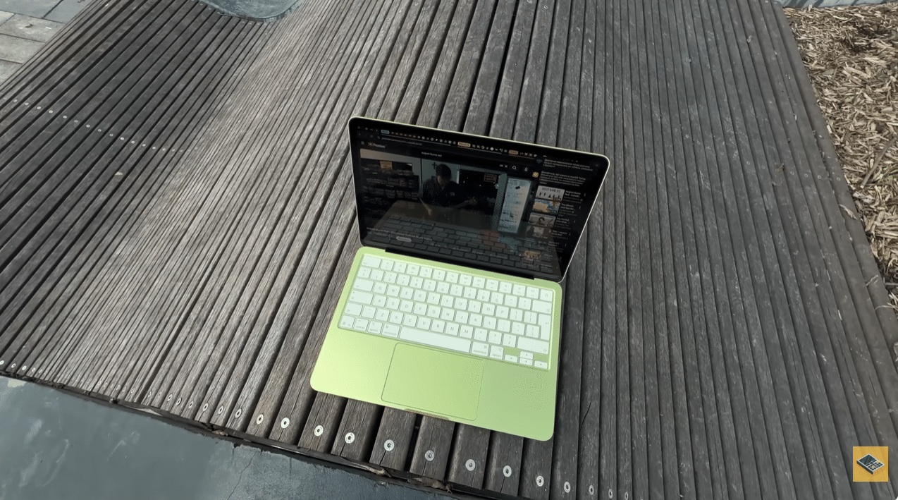 MacBook Neo лимонного кольору на дерев'яній поверхні з відкритим YouTube на екрані