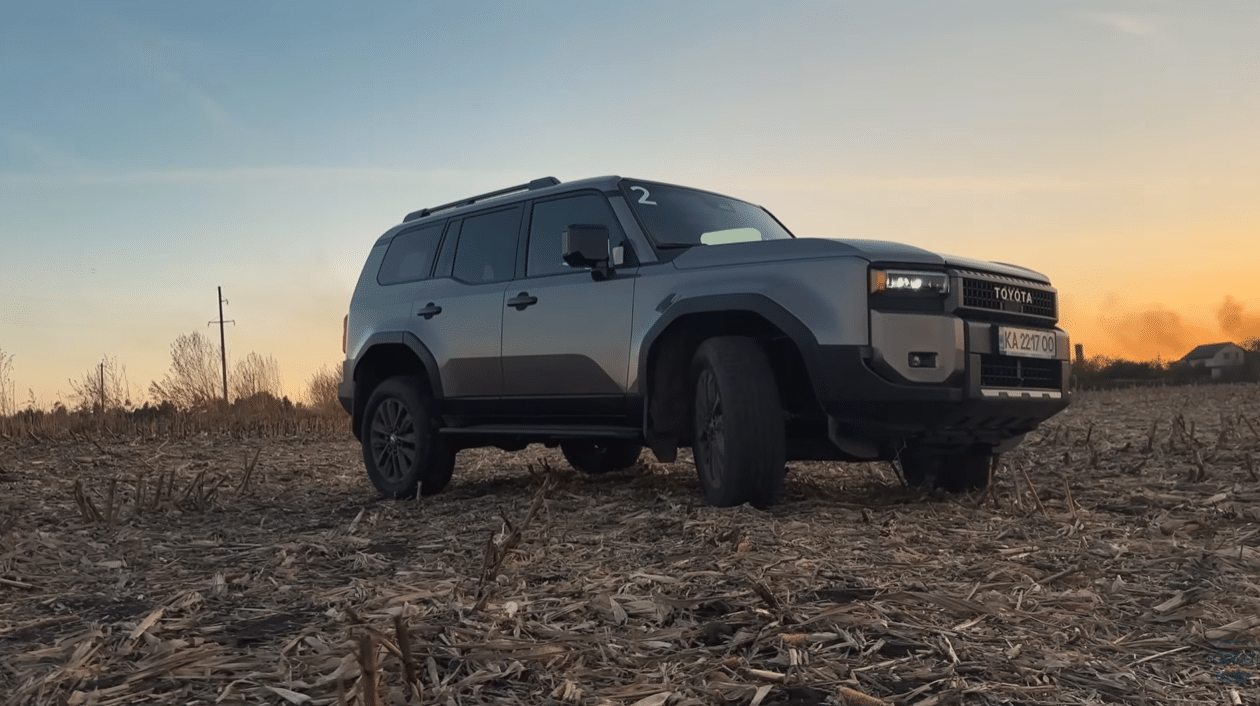 Toyota Land Cruiser Prado сріблястого кольору на полі під час заходу сонця під час тест-драйву