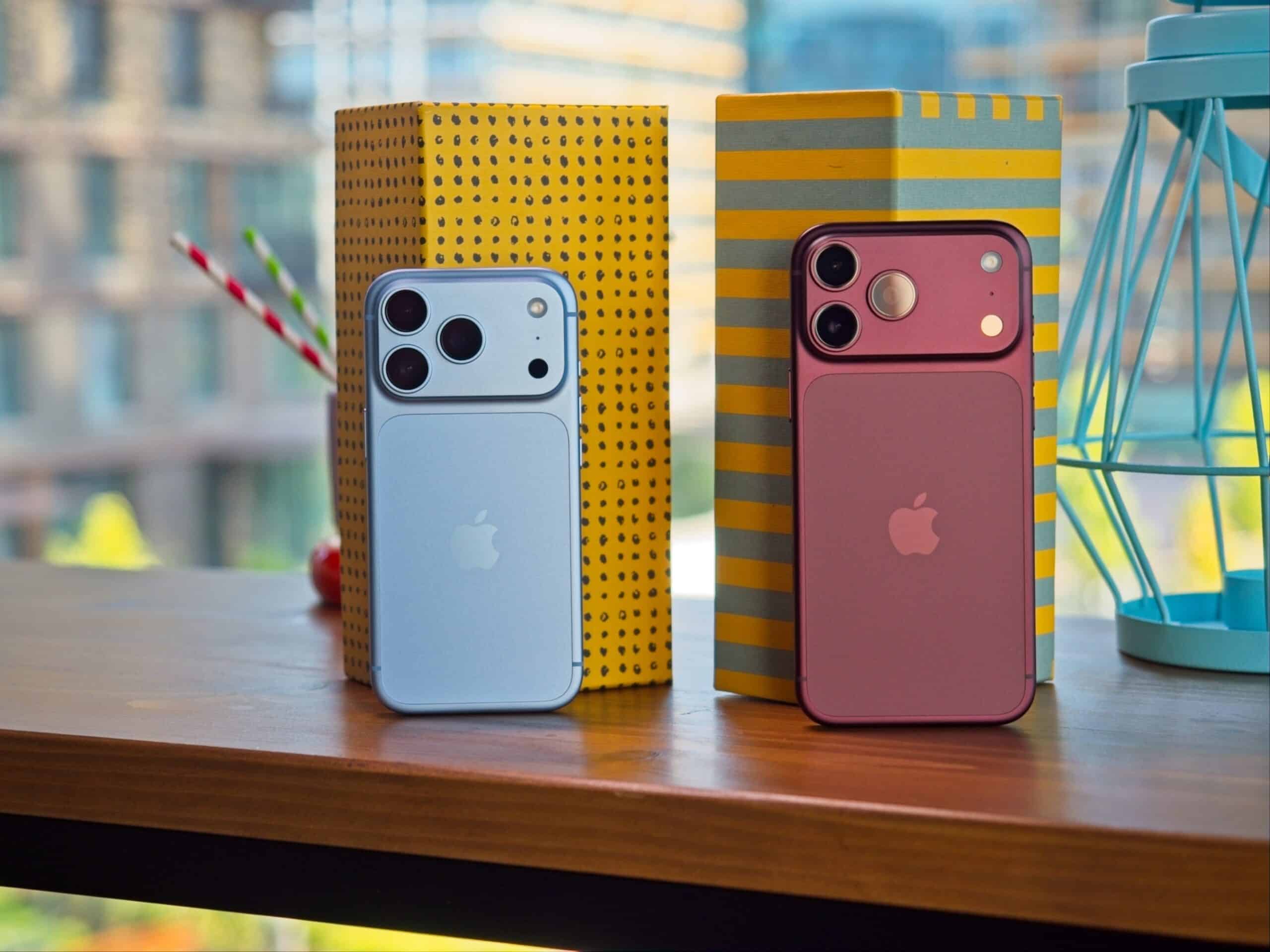 IPhone 18 Pro світло-блакитного та бордового кольорів стоять на дерев'яному столі серед геометричних декорацій