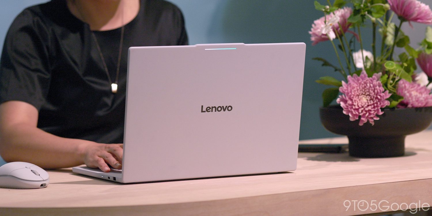 Людина в чорній футболці працює за відкритим ноутбуком Lenovo з рожевим екраном, поруч на столі лежить миша і стоїть горщик