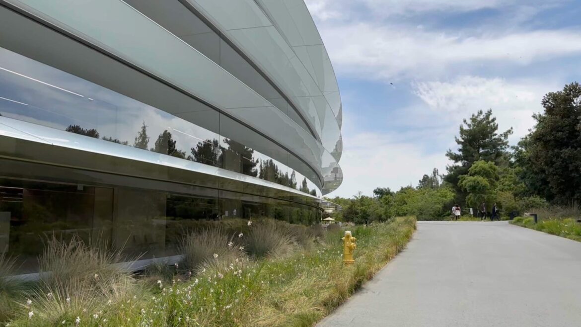 Сучасна будівля з скляним фасадом та озеленення біля входу, архітектурний комплекс Apple