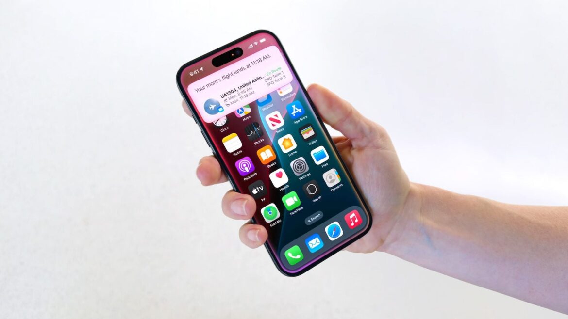 IPhone фіолетового кольору у руці з включеним екраном та іконками додатків