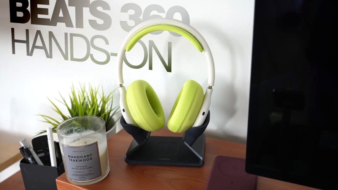 Навушники Beats 360 зеленого кольору на підставці на столі з рослиною та свічкою