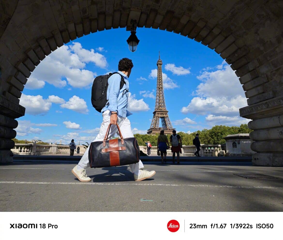 Із основної камери Xiaomi 18 Pro: турист біля Ейфелевої вежі в Парижі з дорожною сумкою