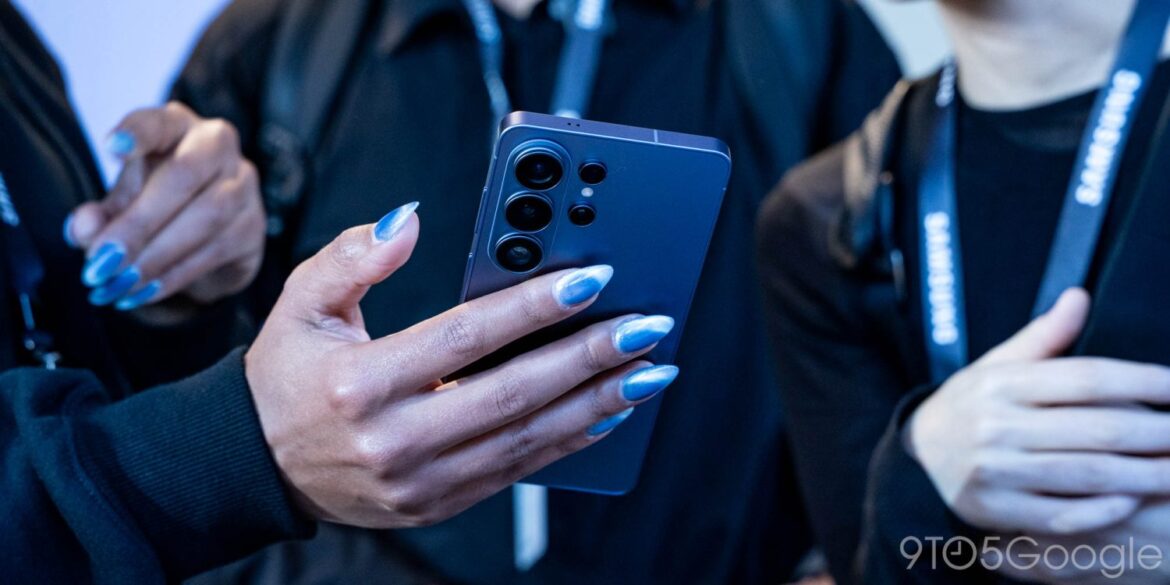 Людина тримає синій смартфон Samsung з квадратним блоком камер, демонструючи пристрій на презентації