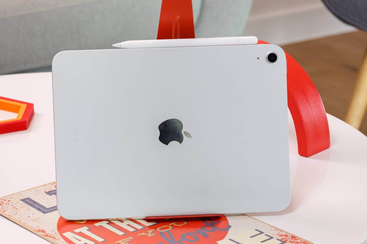 Білий iPad з логотипом Apple лежить на столі рядом з червоною підставкою та стилусом Apple Pencil