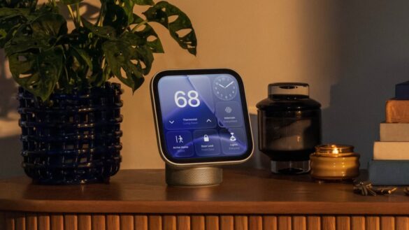 Розумний дисплей HomeView на столі поруч із кімнатною рослиною, чорним гаджетом та декоративними предметами, показує