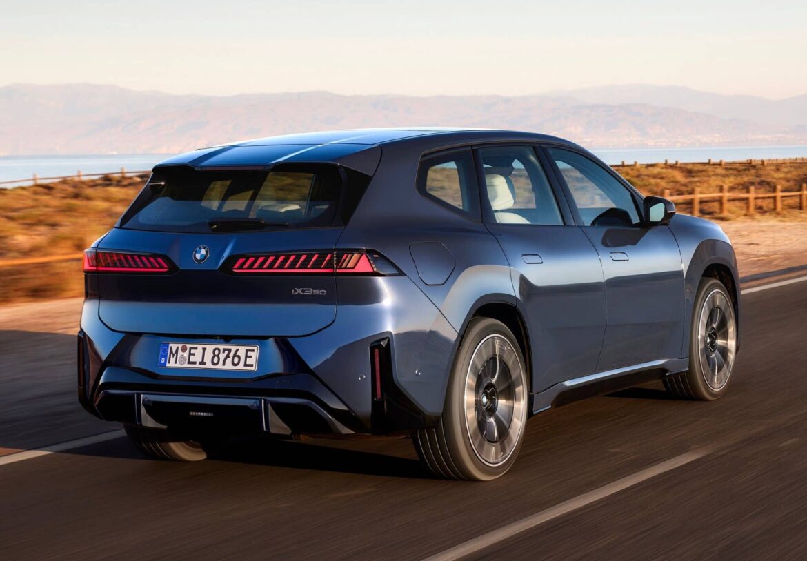 BMW iX3 синього кольору їде по дорозі біля води з багатирядними задніми ліхтарями