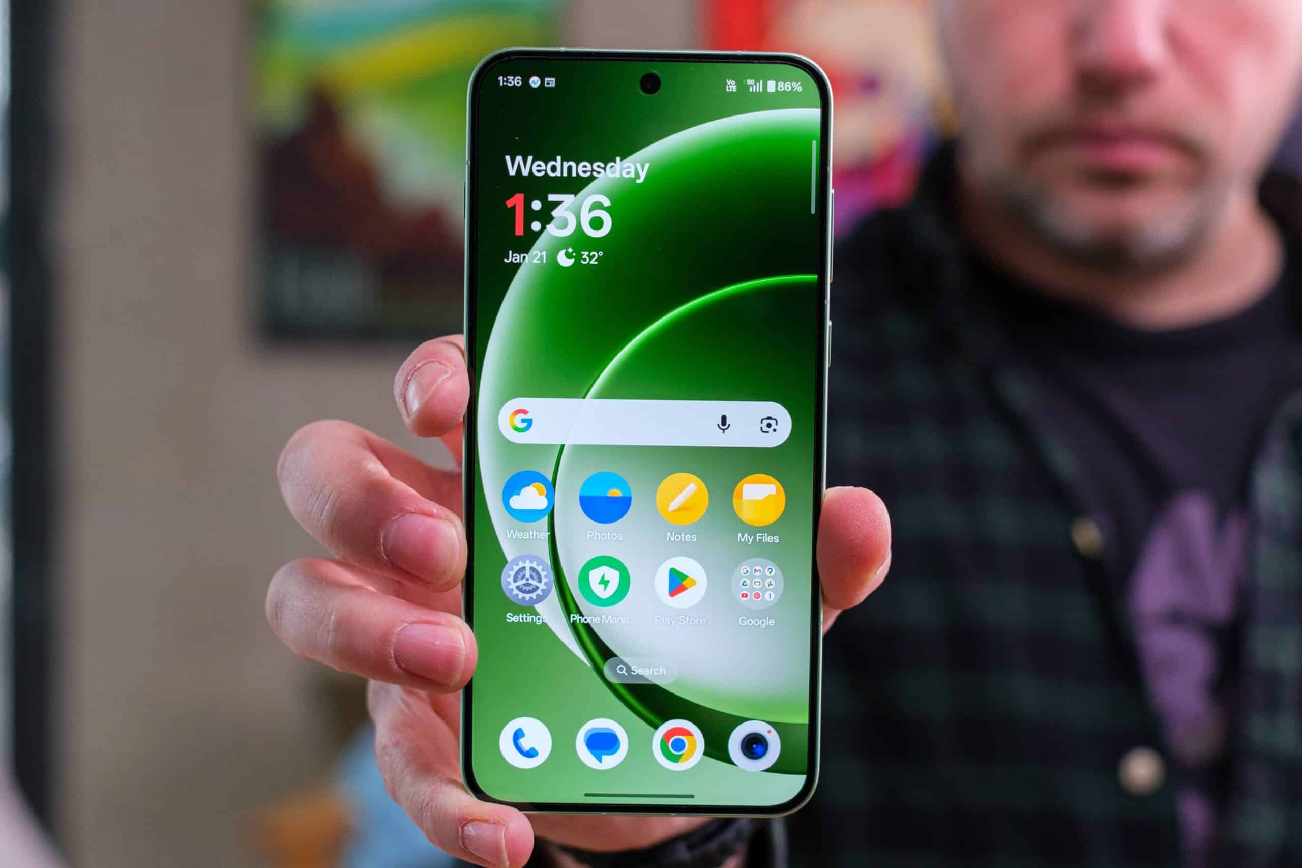 Смартфон OnePlus Ace 7 з зеленим дисплеєм у руках демонструє час 1:36 і домашній екран з іконками додатків