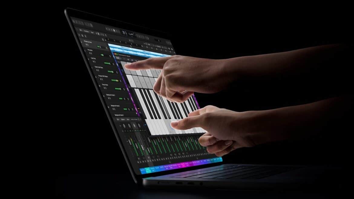 Дві руки торкаються екрана MacBook Pro з музичним редактором, де видно піаніно та доріжки мікшера