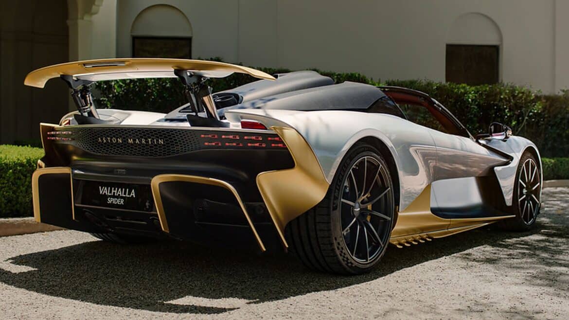 Задня частина срібно-золотого Aston Martin Valhalla Spider з великим спойлером на гравійній доріжці