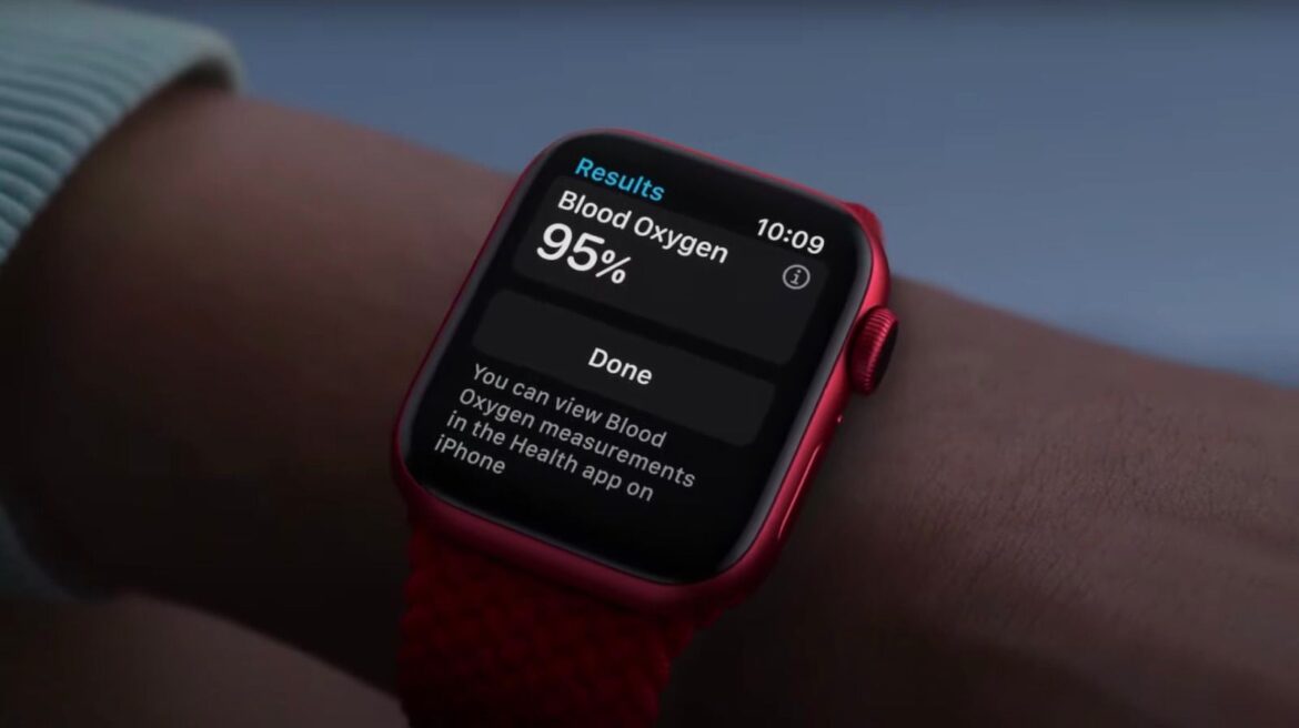 Apple Watch червоного кольору на руці з результатом вимірювання рівня кисню в крові 95%, що стосується патентного спору з