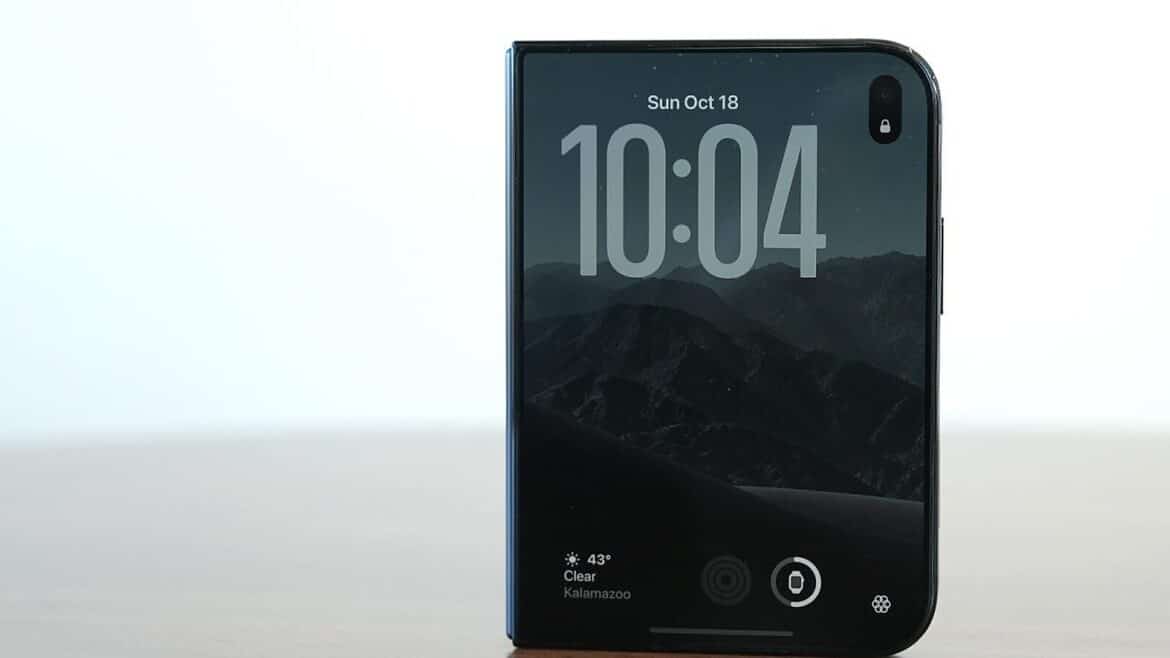 Складаний смартфон стоїть на столі, на екрані блокування час 10:04 і гірський пейзаж на шпалерах
