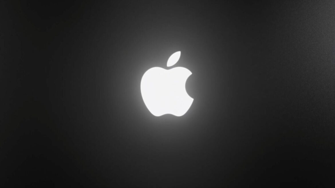 Логотип Apple у білому світінні на темному фоні, як підсвічений логотип на кришці MacBook Pro