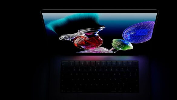 Відкритий MacBook Pro з підсвіченою клавіатурою, на екрані абстрактні 3D-форми червоного й синього кольорів