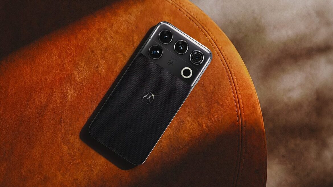 Чорний смартфон Motorola з блоком камер на задній панелі лежить на коричневій шкіряній поверхні з м'яким освітленням